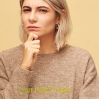 Vältä vääriä sopimuksia sugar dating, miten ne havaitaan? Nainen pitää kättään leualla ja katsoo epäilevästi.